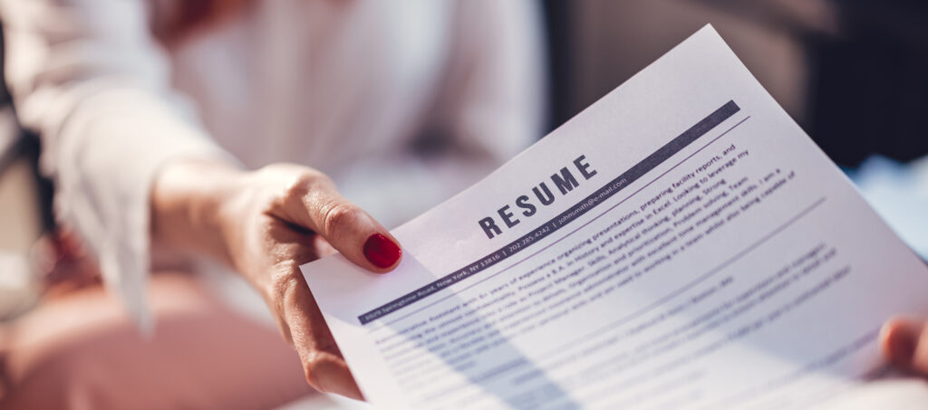 The concept of employment and job interviews. Young woman during job interview, main focus on resume.